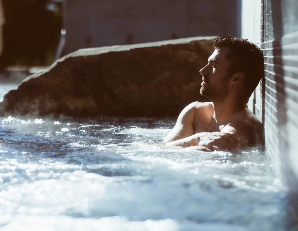 Homme se relaxant dans un spa extérieur