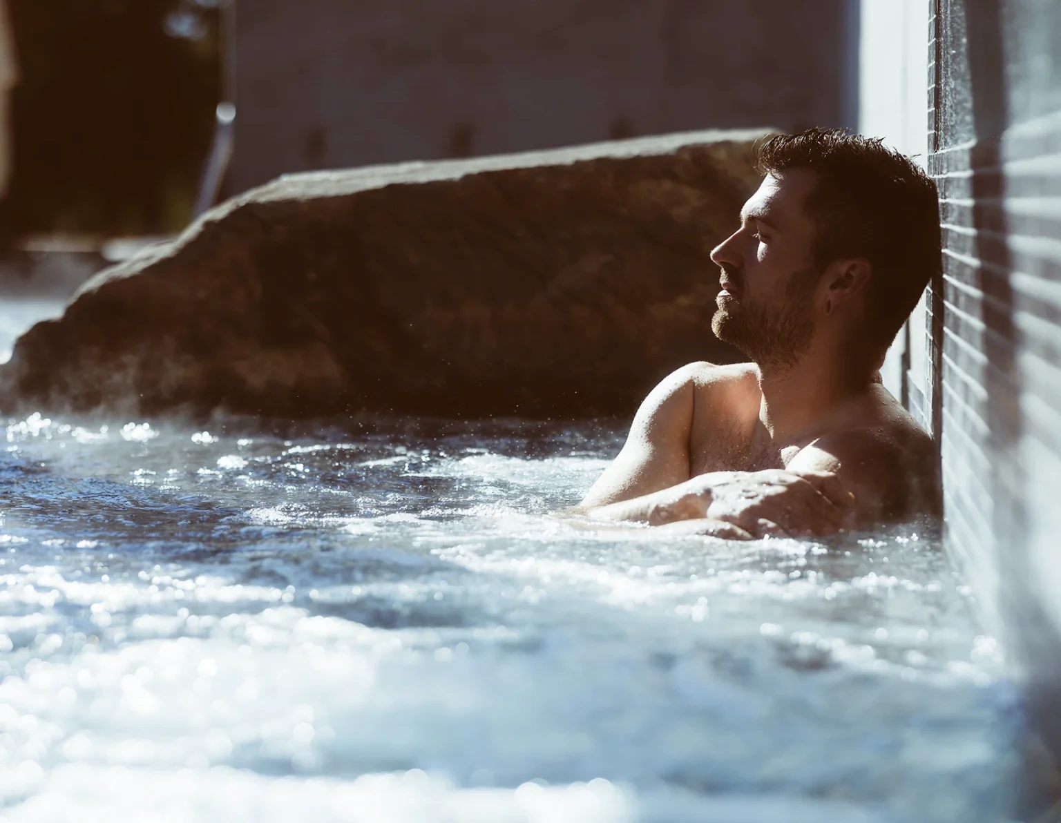 Homme se relaxant dans un spa extérieur