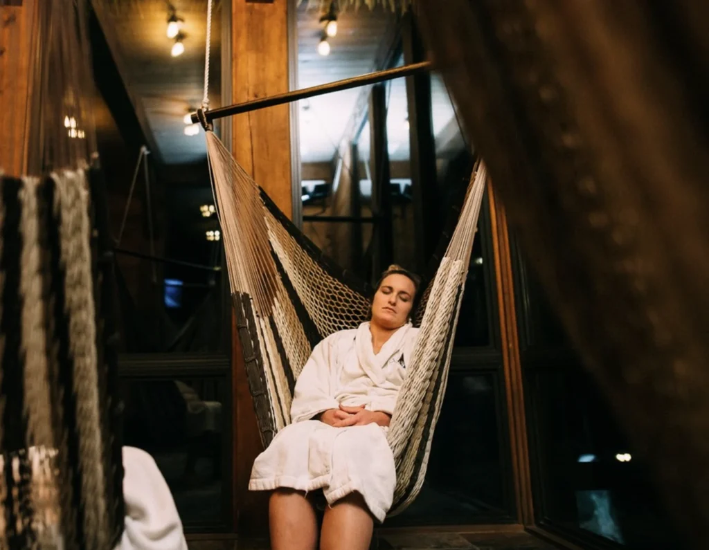 Femme en peignoir relaxant dans un hamac intérieur