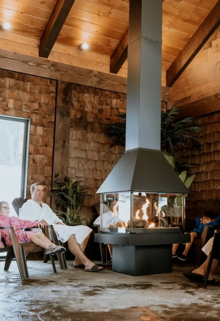 Famille relaxant près d’un foyer moderne intérieur