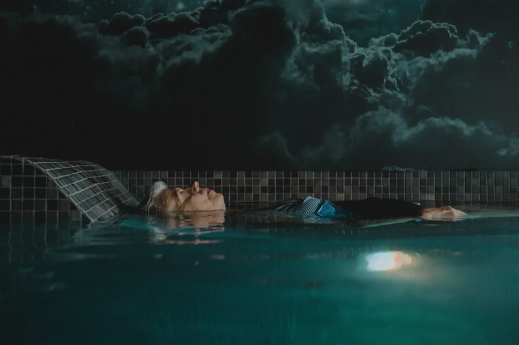 Personne flottant sur le dos dans une piscine
