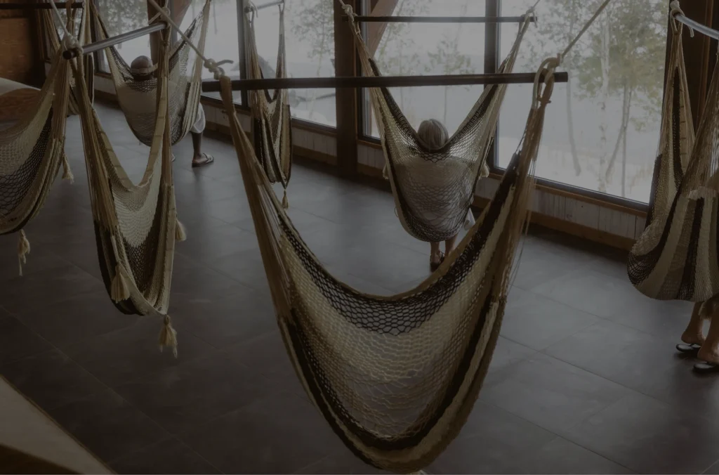 Personnes relaxant dans des hamacs intérieurs lumineux