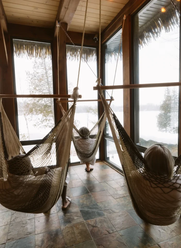 Personnes relaxant dans hamacs près grandes fenêtres