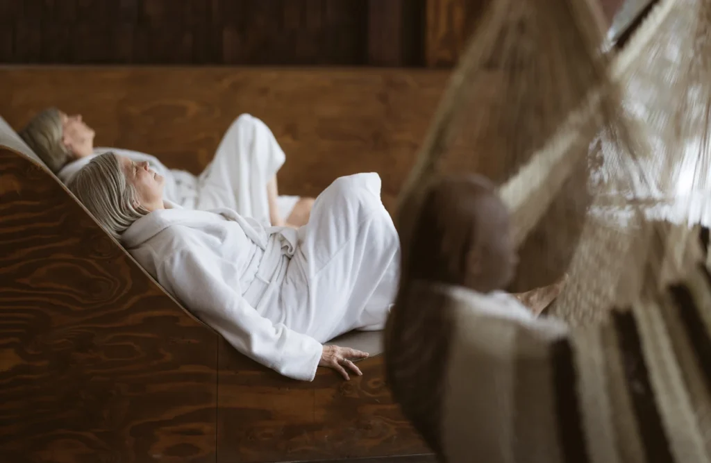 Deux femmes en peignoir relaxent sur chaises en bois