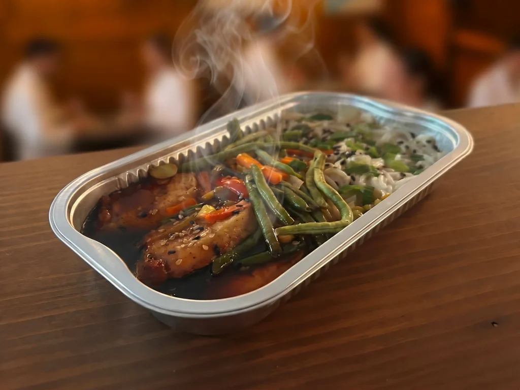 Repas chaud à emporter avec saumon et légumes